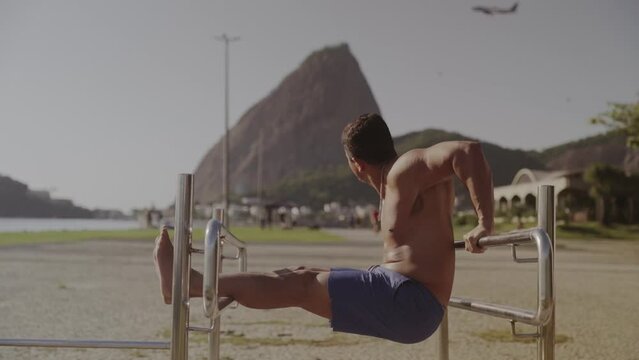 Jovem forte fazendo exercicios ao ar livre no Rio de Janeiro, Brasil. Cinematico 4k.