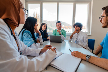 A medical team of doctors discussing and planning a work strategy at a meeting in the conference...