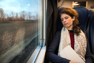 Mid Adult Caucasian Woman Sleeping on a Train While on the Way on Job in Morning Light