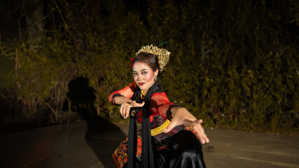 a female dancer in a red dress danced on stage, reflecting the beauty of her movements and adding...