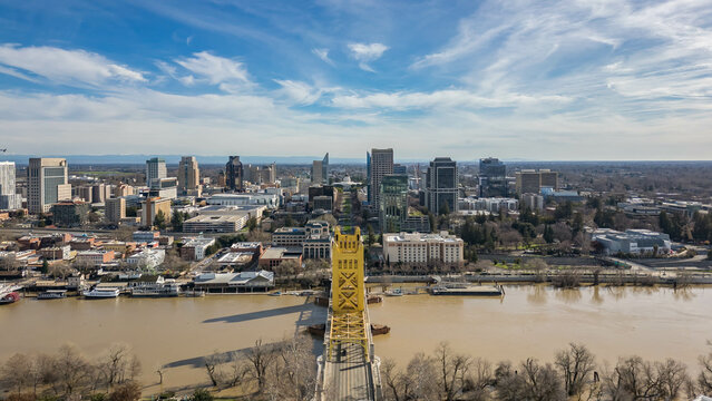 Aerial image of the tower bridge and the State Capitol building in downtown Sacramento, California. With the Sacramento River in the foreground after a rainstorm