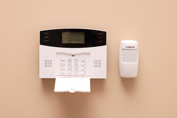 Home security alarm system on beige wall - obrazy, fototapety, plakaty