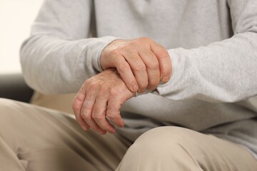 Senior man suffering from pain in hand, closeup. Rheumatism symptom