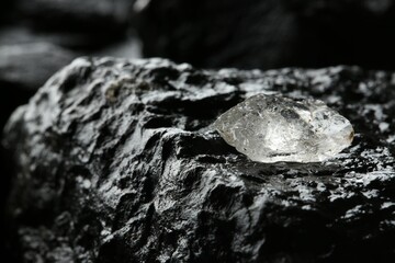 Shiny rough diamond on stone surface, closeup. Space for text