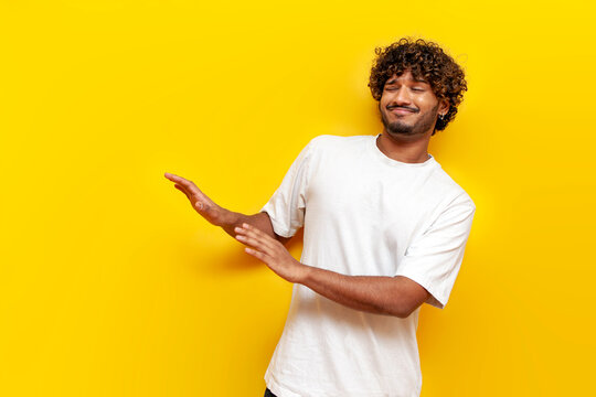 young indian guy avoiding and refusing on yellow isolated background, displeased south asian man