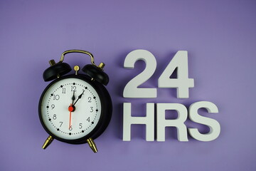 24 HRS alphabet letters with alarm clock top view on purple background, business and education concept background