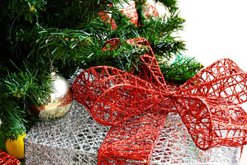 Christmas ornament below pine tree.