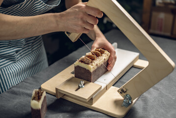 Cutting of homemade natural chocolate soap on a professional wood cutter. A means of eco-friendly hygiene and pleasant gifts