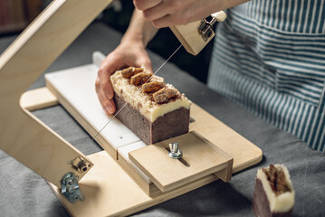Cutting of homemade natural chocolate soap on a professional wood cutter. A means of eco-friendly hygiene and pleasant gifts