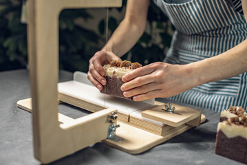 Cutting of homemade natural chocolate soap on a professional wood cutter. A means of eco-friendly...