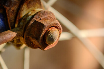 Rusty bicycle wheel nut on natural light.