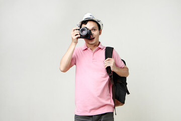 Asian man backpacker taking photo with digital camera. travelling concept. on isolated background
