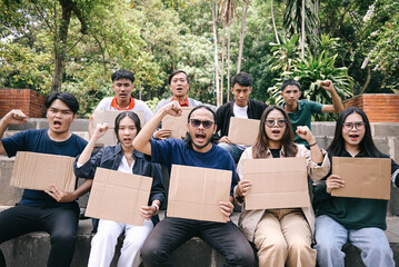 Group of activist raising hands and holding blank cardboard during a rally or demonstration