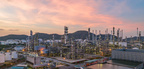 Fototapeta na wymiar Oil and gas industrial refinery at twilight, Oil refinery and Petrochemical plant pipeline steel, Refinery factory oil storage tank and pipeline steel at night.