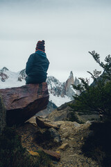 woman sitting on a rock looking at cerro torre in patagonia