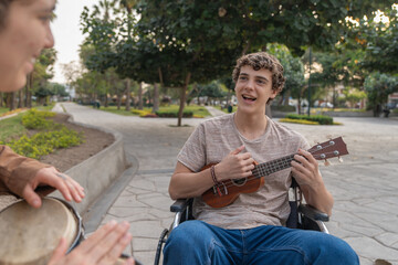 Disabled man in wheelchair and friend playing music outdoors