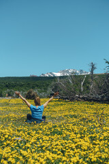woman feeling the freedom of being in nature in a field of yellow flowers