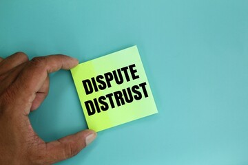 hand holding colored paper with the word dispute distrust. dispute concept