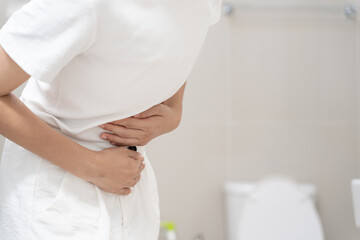 Constipation and diarrhea in bathroom. Hurt woman touch belly  stomach ache painful. colon...