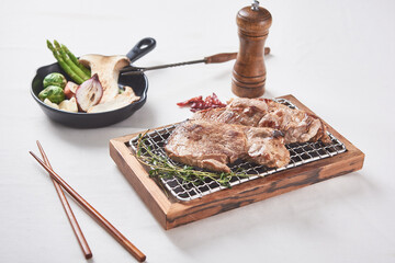 Pork neck that is deliciously grilled on a white background and golden brown on a brazier