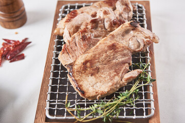Pork neck that is deliciously grilled on a white background and golden brown on a brazier