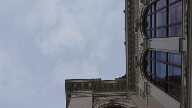 Building exterior with ornaments and large arched windows during overcast day