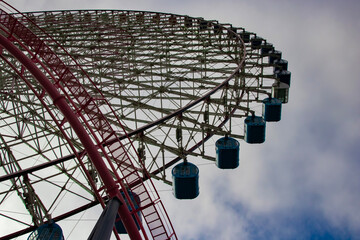 A ferris wheel behind the blue sky in Yokohama sunny day low angle