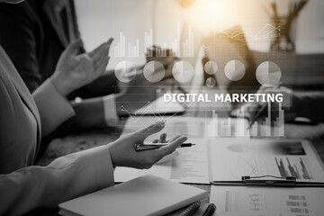 Business environment with professionals and graphics overlay with the text "DIGITAL MARKETING" during a meeting.
