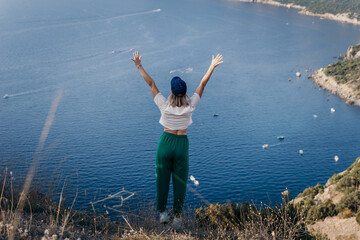 Fototapeta na wymiar Happy woman standing with her back in nature in summer with open hands posing with mountains. Woman in the mountains, eco friendly, summer landscape active rest