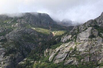Clouds hanging over the top of rugged mountains in Southern Alaska