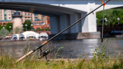 Close-up fishing rod tip, fishing rod near bridge in city, fishing in metropolis