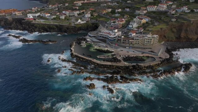 volcanic pools of Porto Moniz in Madeira Potrugal fottage with drone of cliffs, ocean, atural bathing spots, houses filmed at sunset.