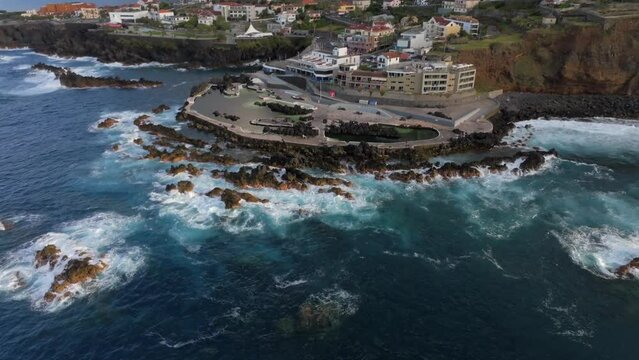 volcanic pools of Porto Moniz in Madeira Potrugal fottage with drone of cliffs, ocean, atural bathing spots, houses filmed at sunset.