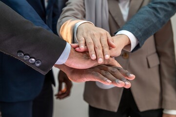 multiethnic business teamwork putting join hands together. Unity and teamwork show by Stack mix of...