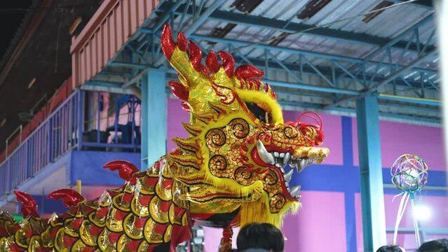 person performing a dragon dance during Chinese New Year celebrations is believed to bring blessings and good fortune for the upcoming year. Hidden under a dragon costume, performers move in harmony	