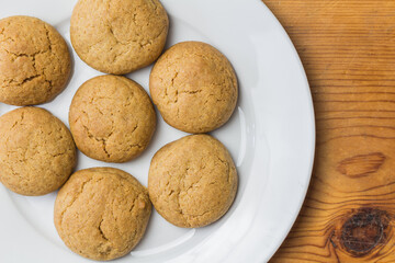 Traditional homemade festive ginger snaps - ginger biscuits on white plate with copy space
