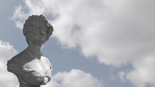 Animation of gray sculpture of man over blue sky and clouds, copy space