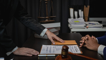 Lawyer holds a pen and provides consulting services in business disputes with a scale and hammer....