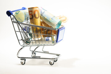 shopping cart full of rolled up euro banknotes, isolated on a white background