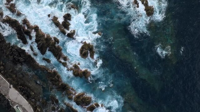 volcanic pools of Porto Moniz in Madeira Potrugal fottage with drone of cliffs, ocean, atural bathing spots, houses filmed at sunset.