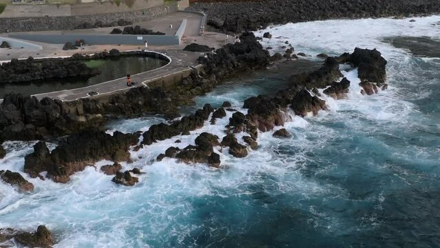 volcanic pools of Porto Moniz in Madeira Potrugal fottage with drone of cliffs, ocean, atural bathing spots, houses filmed at sunset.