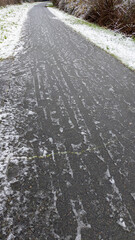 Car tracks on snowy road frozen ground