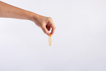 Yellow rubber bands close up with hand isolated on white background