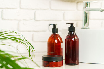 Soap and cream dispenser jars near the sink in a bathroom