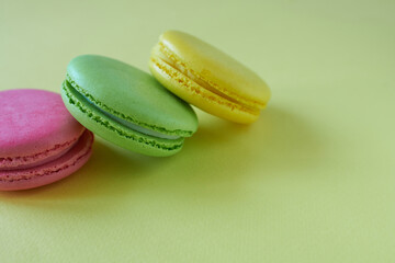 Colorful macaroons on a green background. Close up.