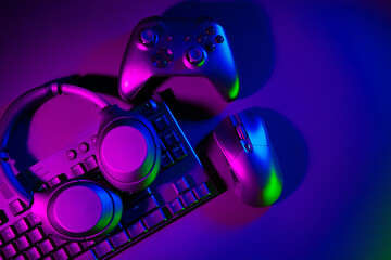 Headphones, computer mouse and keyboard on black background