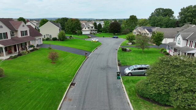 Rural American neighborhood during late summer. Aerial establishing shot of houses and homes in a cul-de-sac.
