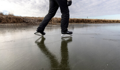 skating on the ice of a frozen lake without snow