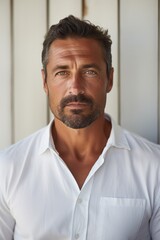 Obraz premium A picture of a man with a beard wearing a white shirt. This versatile image can be used for various purposes