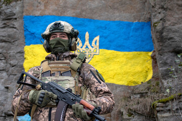 Ukrainian soldier against ukrainian flag painted on granite wall